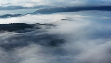 Montañas-Brumosas-Con-Nubes-Fluidas-Al-Amanecer,-Escena-Natural-Etérea,-Vista-Aérea