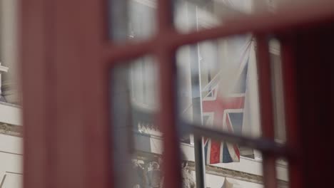 the union jack flag seen through a british red telephone box.