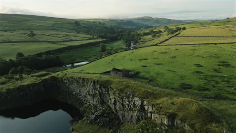 Establishing-Drone-Shot-Over-Disused-Quarry-and-Barn-at-Golden-Hour