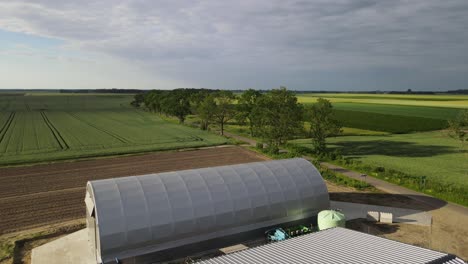 arched hall storage warehouse production farm facility in field sunny