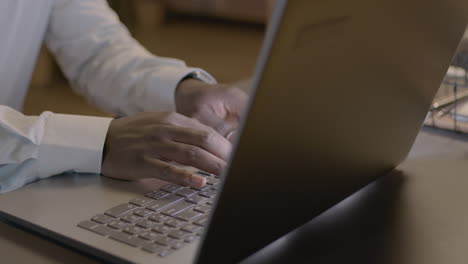 close up of american male hands typing on laptop keyboard at workplace