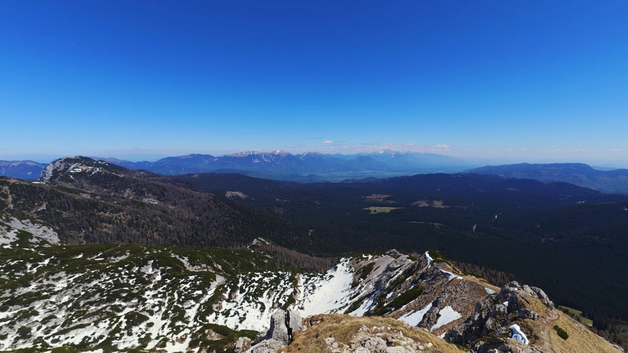 Altopiano di Pokljuka, Slovenia, dalla cima del Viševnik con le Alpi Giulie innevate, creste montuose aspre e il paesaggio del Parco Nazionale del Triglav