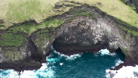 Birds-flying-around-above-the-wild-sea-splashing-on-the-rocks-at-Westman-Islands