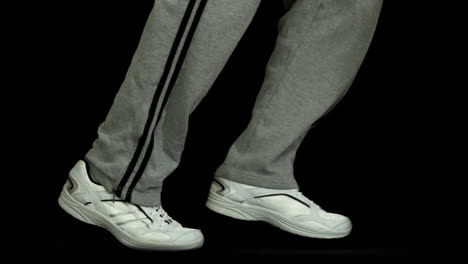 Legs-in-tracksuit-running-against-black-background