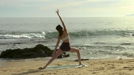 an attractive young woman practicing yoga on a beautiful california beach-2