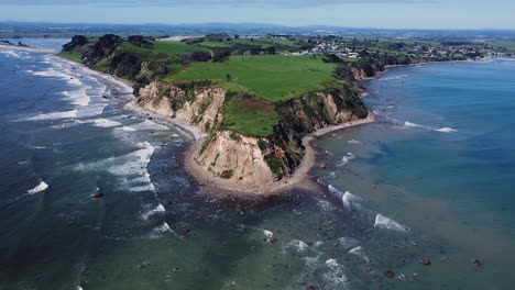 promontorio y playa pedregosa en maketu, isla del norte, nueva zelanda - toma aérea de drones