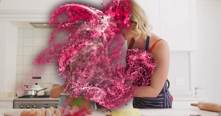 Mother teaching daughter cracking eggs while red-pink particles emerging at bowl obscuring cooking