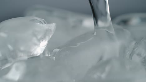 stream of water pouring on ice cubes close-up