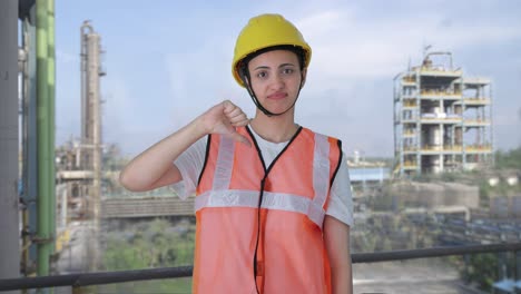 una trabajadora de la construcción india molesta mostrando los pulgares hacia abajo