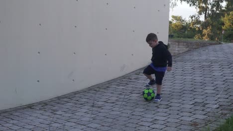 Niño-Griego-Caucásico,-Jugando-Con-Una-Pelota-Al-Aire-Libre