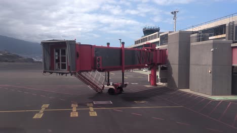 puente de embarque de pasajeros puente de reacción alejándose del avión en el aeropuerto internacional de la palma durante el sol de la mañana dedo