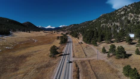 Snow-Capped-Mountain-Range-Car-On-Highway-Aerial-Shot-4K