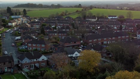 Pequeño-Barrio-De-Propiedades-De-Una-Ciudad-Británica-En-El-Borde-De-Tierras-Agrícolas-Rurales-Al-Atardecer-Vista-Aérea