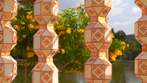 rows of beautiful thai lanterns softly waving in wind in nature setting