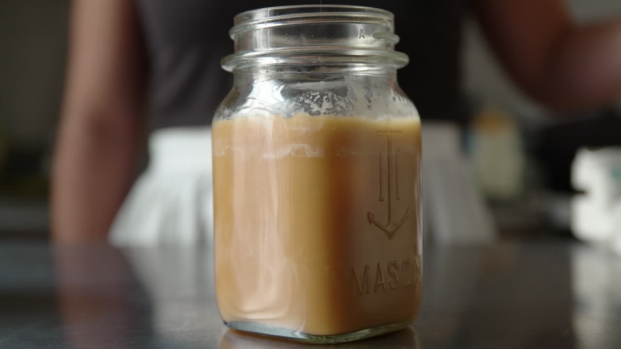 Donna mette cubetti di ghiaccio nel caffè cremoso