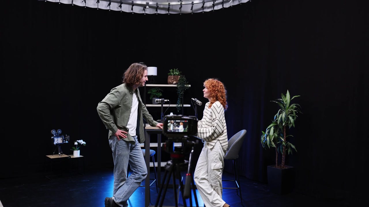 To unge voksne optager et podcastinterview i et moderne studie