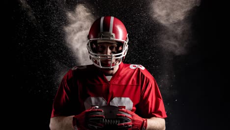 Animation-of-portrait-of-american-football-player-holding-ball-over-smoke,-on-black-background
