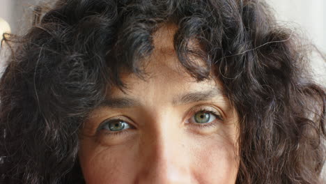 Close-up-of-a-biracial-woman-with-curly-black-hair-and-blue-eyes