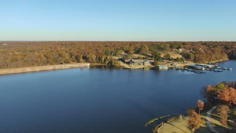 early evening aerial view around the bend past the retirement community lake marina club house