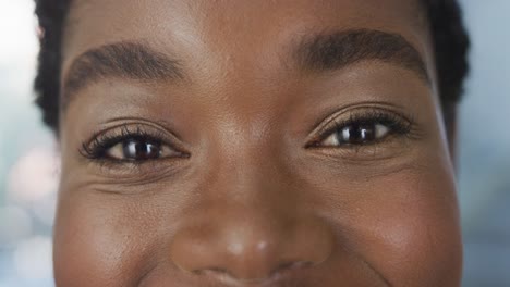 portrait of happy african american female doctor smiling and looking at camera at hospital