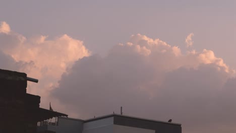 Timelapse-De-Nubes-Que-Se-Mueven-Rápidamente-Durante-La-Puesta-De-Sol-Con-Edificios-Residenciales-En-Primer-Plano