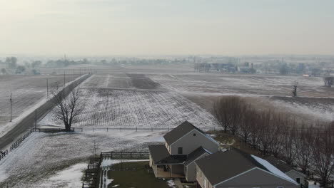 Aerial-shot-of-homestead-with-farmlands-in-rural-area---Drone-lifitng-up