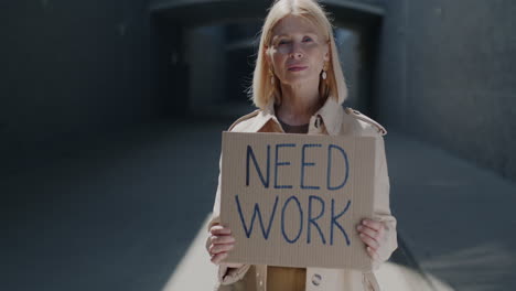 woman holding "need work" sign