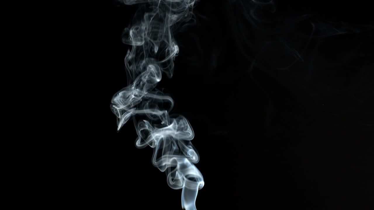검은색 배경에 회색 연기가 아오르며 연기가 사라집니다.