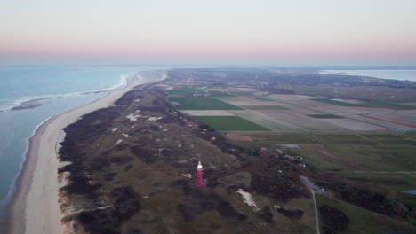 aerial view of westhoofd lighthouse, beach and fields in ouddorp, netherlands in sunrise