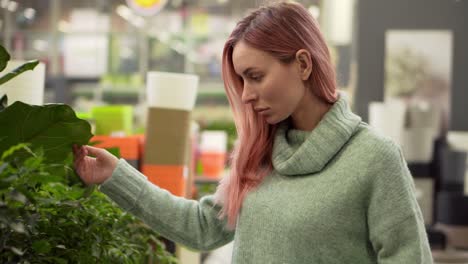 Mujer-Rubia-Eligiendo-Plantas-En-El-Mercado-De-Flores-En-La-Tienda-De-Jardín