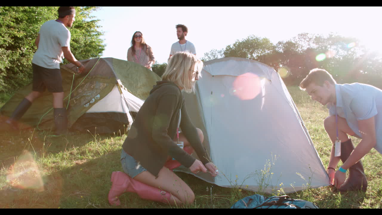 캠핑 휴가 에 텐트 를 세우고 있는 젊은 친구 들 의 그룹