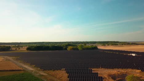 Drohne-Fliegt-An-Einem-Klaren,-Sonnigen-Sommertag-über-Einer-Solarpanel-Basisstation-In-Einer-Natürlichen-Landschaft,-Umweltfreundliche-Produktion-Erneuerbarer-Energien