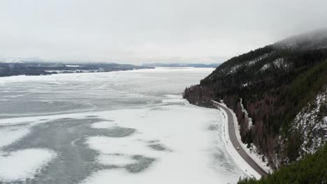 aerial shot of a partially frozen lake or reservoir in the middle of sweden during the midwinter solstice