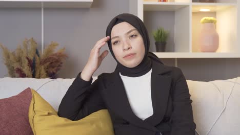 muslim woman wearing a headscarf has a headache.