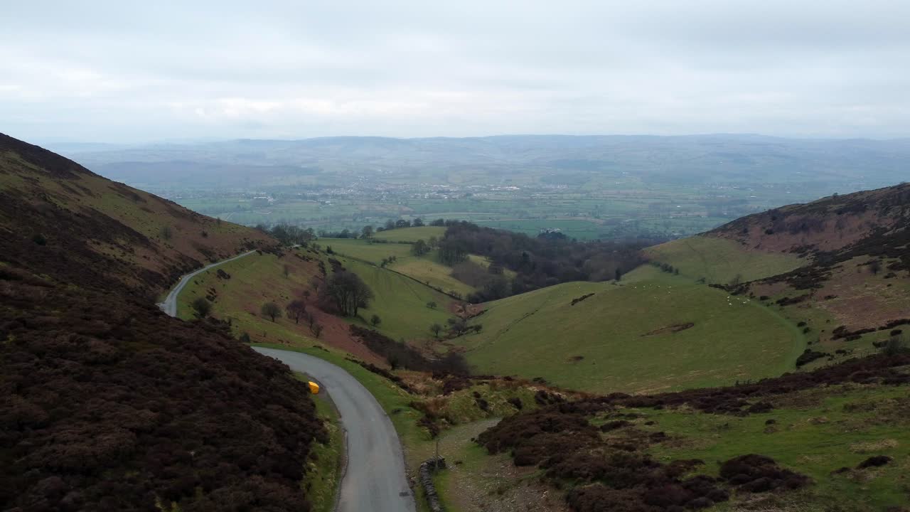 estrecho único camino rural que atraviesa los verdes valles montañosos de gales paisaje antena derecha muñequita