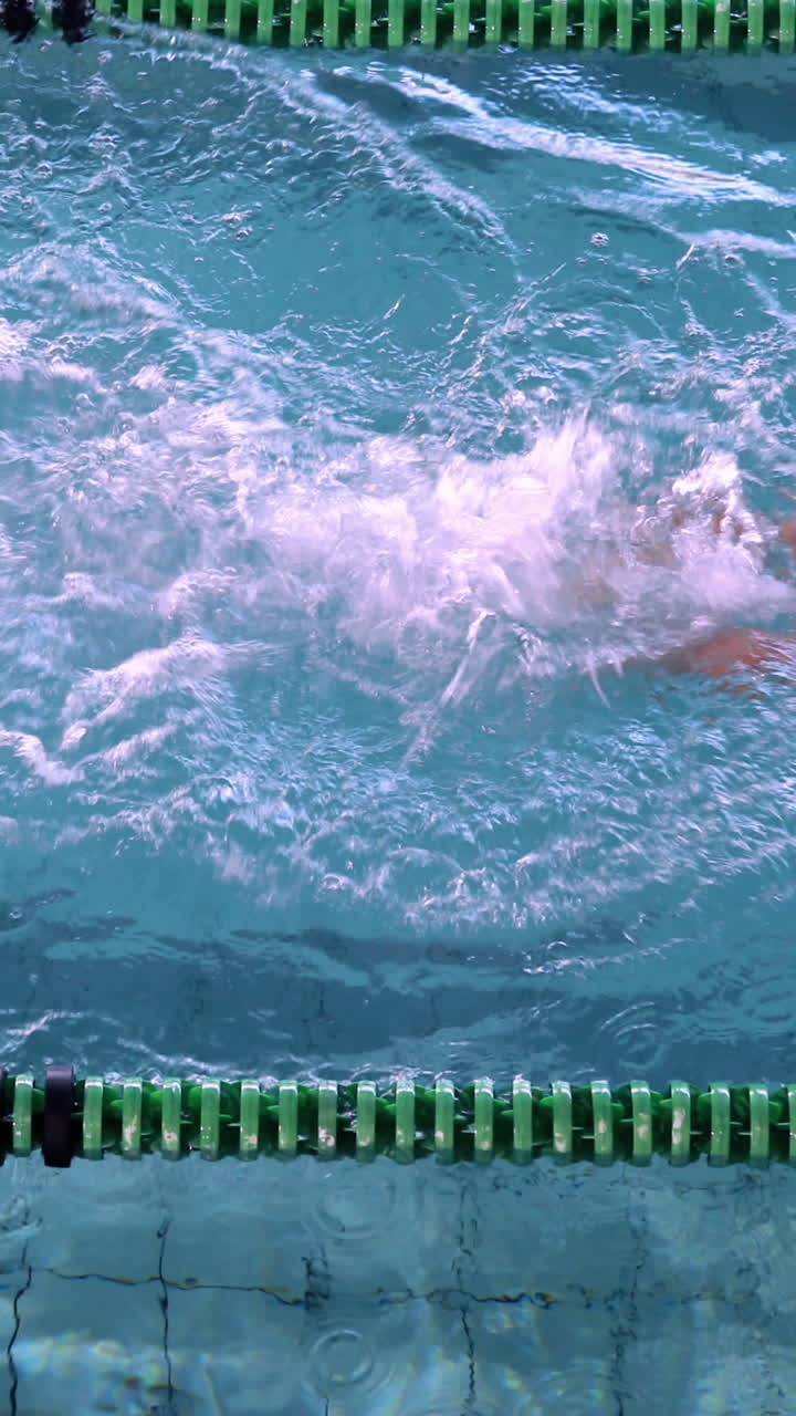 Vertical Video of fit female swimmer doing the front stroke in the swimming pool in the leisure cent