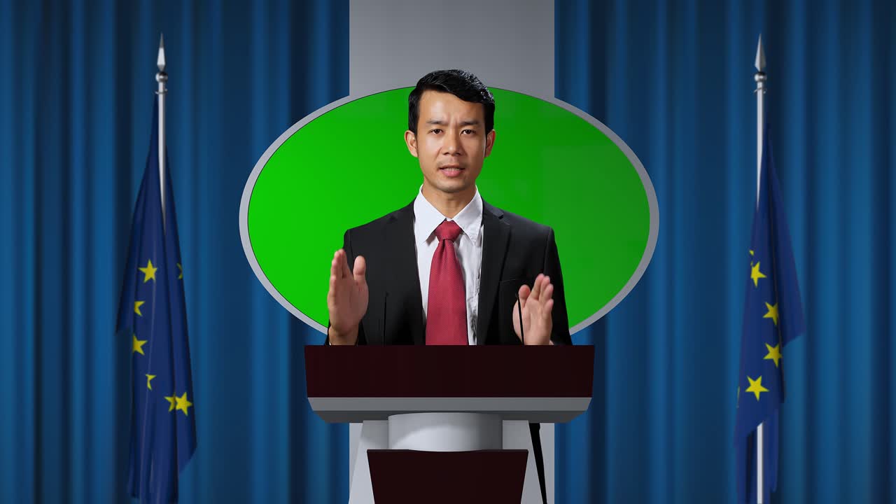Asian Portrait Of Organization Representative Speaking At A Press Conference In Government Building With Mock Up Green Screen, Press Officer Delivering A Speech At A Summit. Backdrop With Eu Flags