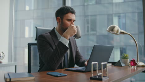 busy manager enjoy coffee at office work on workplace close up. man drinking
