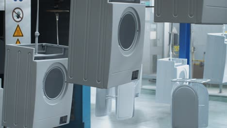 white washing machine moving on conveyor line at manufacturing factory