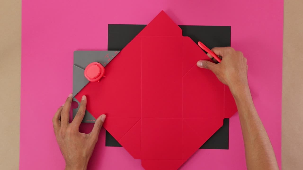 Making notches and folding lines in red paper with puncturing board