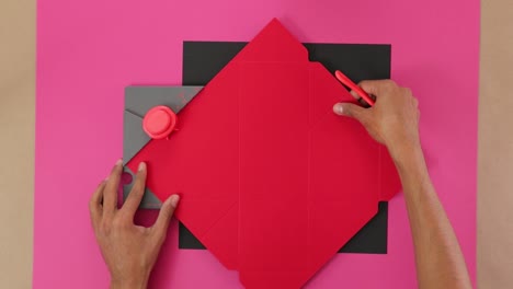making notches and folding lines in red paper with puncturing board