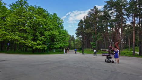 people enjoying a sunny day in a park with a large squirrel statue