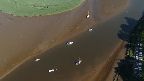 aerial of the river exe when the tide is out, stranded boats and resting birds scatter the shore