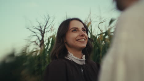 a young woman smiling in a cornfield