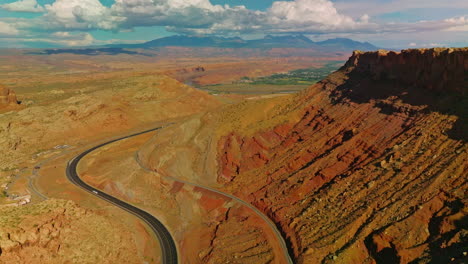 rocky scenery of amazing canyons in utah, usa. motorway leading to the green valley. stunning cloudscape at backdrop.