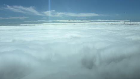 immersive pilot pov fpv flying over a sea of clouds with the sun shining ahead. aerial footage taken from a jet cockpit. sunny day with a blue sky. 4k 60fps
