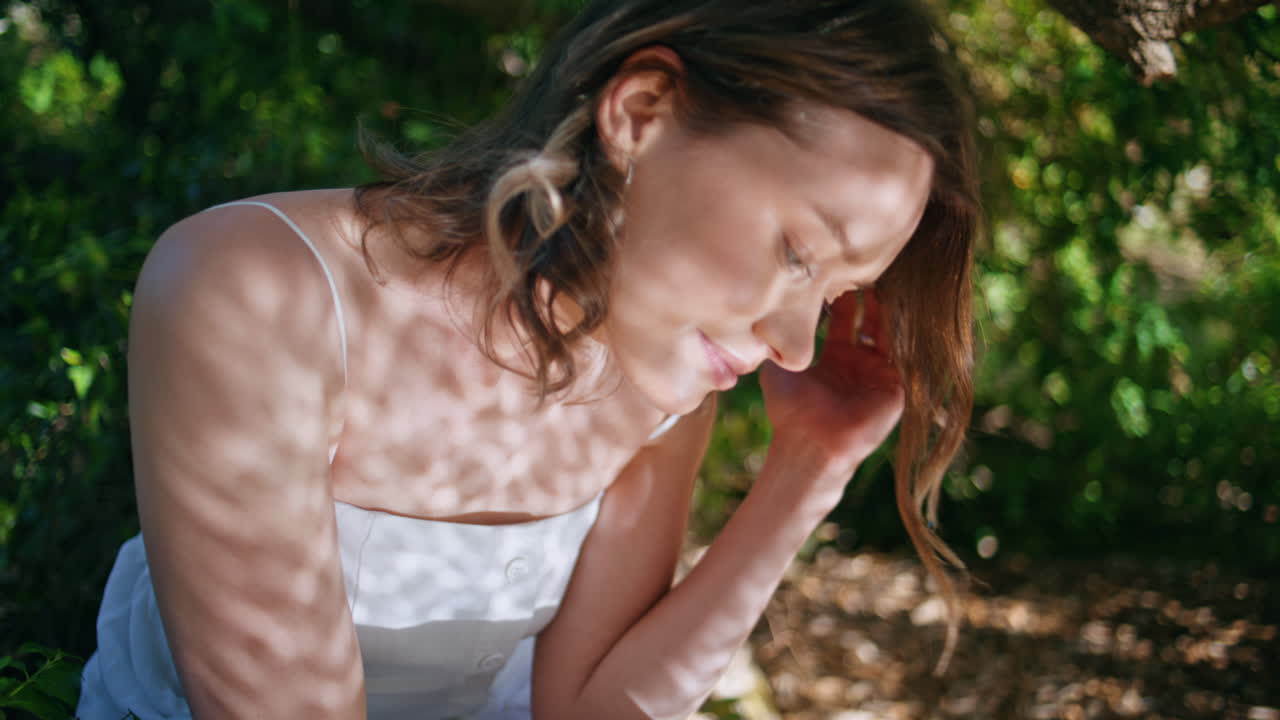 Thoughtful girl resting nature forest reflecting sun shadows on face closeup