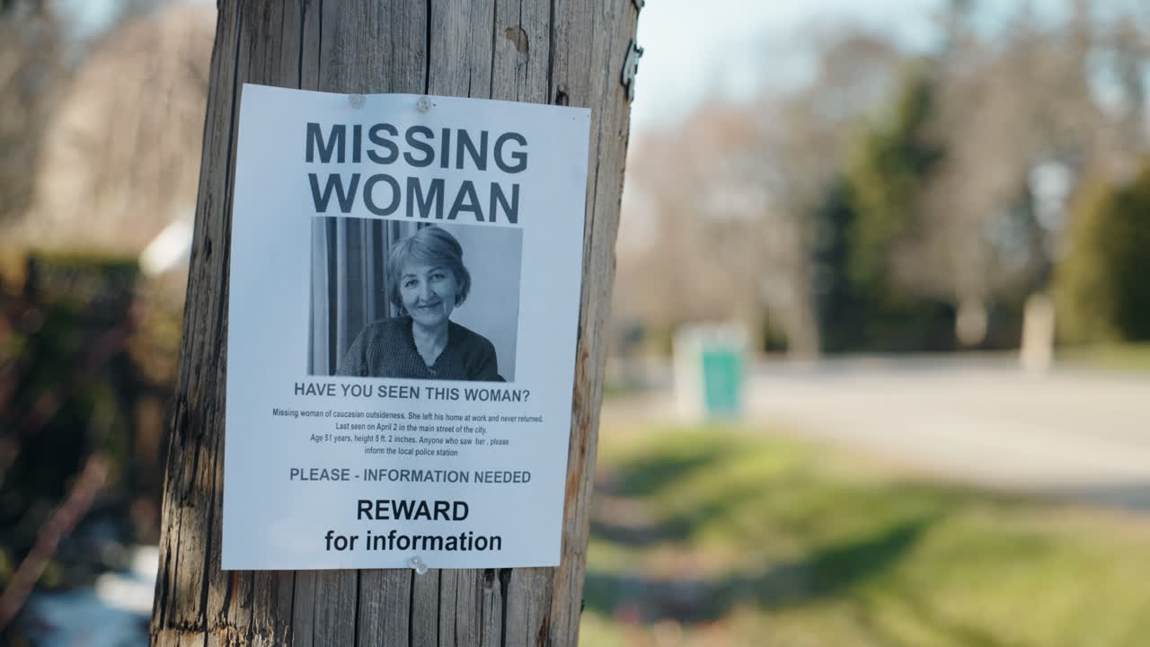 Missing woman poster with photo on wooden pole, public notice seeking information about disappeared person in suburban street