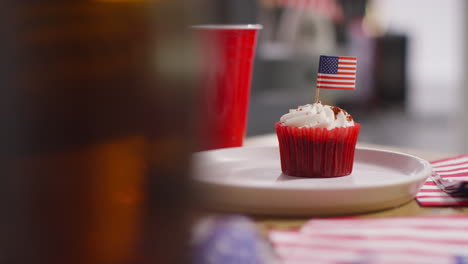 close up of cupcakes with american stars and stripes flags and bottles of beer at party celebrating 4th july independence day 3