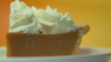 [camera used: canon c300] macro, pan left, low angle, rack focus, pumpkin pie slice with whipped cream